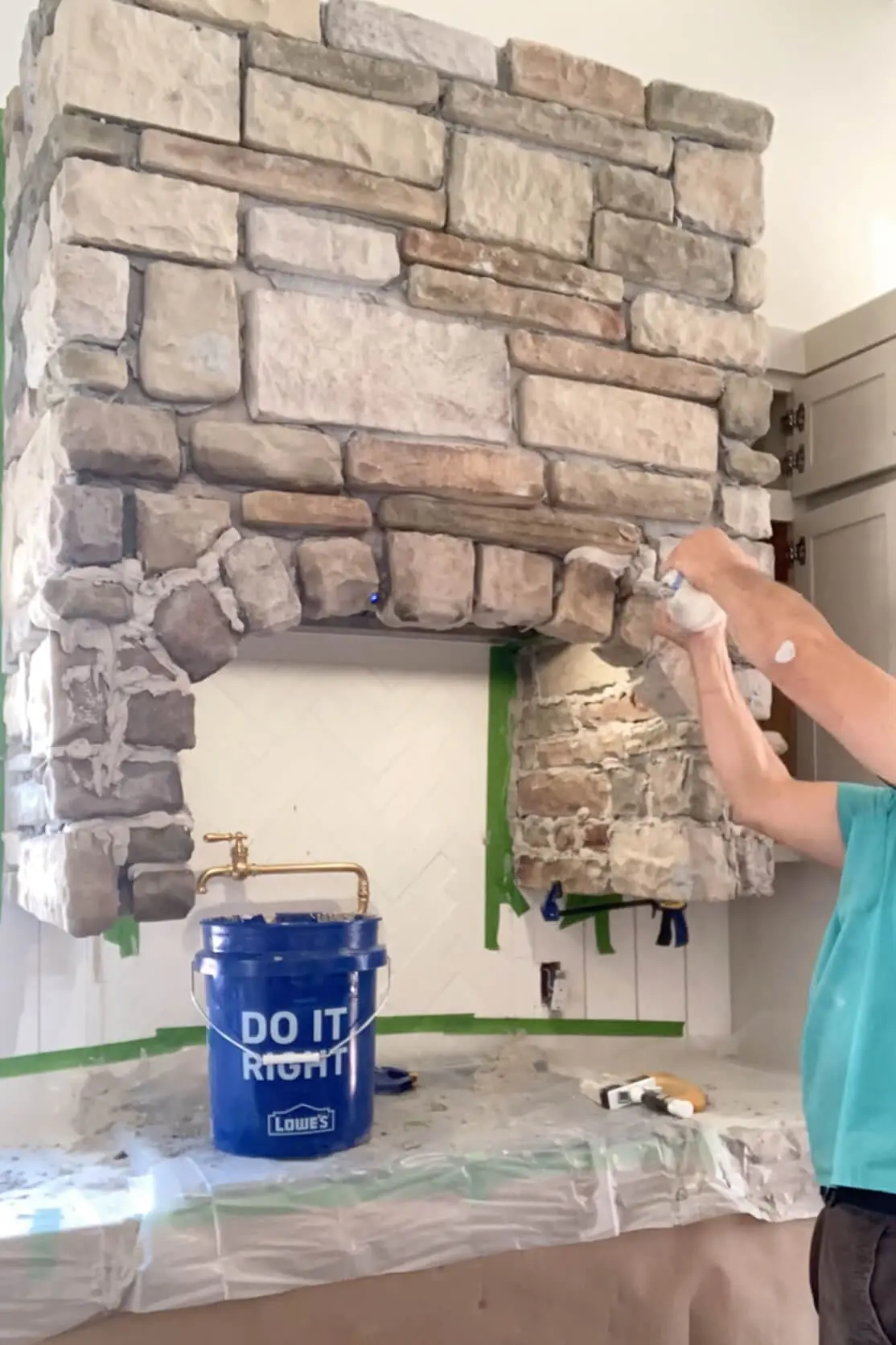 Using a mortar bag to finish a DIY stone range hood.